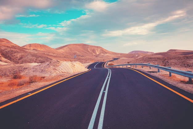 Guidare un'auto su una strada di montagna paesaggio desertico la strada da arad al mar morto vista dall'auto del paesaggio di montagna in una giornata di sole israele