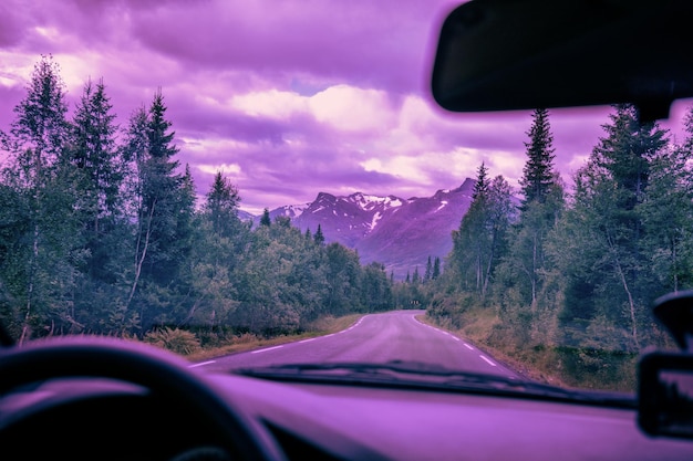 Driving a car on a mountain road. Toned of trendy velvet violet color