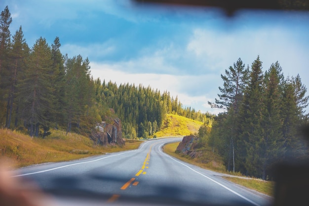 Guidare un'auto su una strada di montagna vista dal parabrezza della splendida natura della norvegia