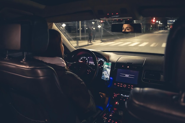 Driving a car at night a woman driving her modern car at night in the city