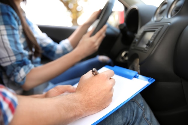 Driving instructor writing down results of exam closeup