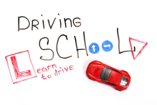 Driving school chalkboard, Educational and Creative composition with the Driving school caption. toy car model. traffic signs. White isolated background, board for markers