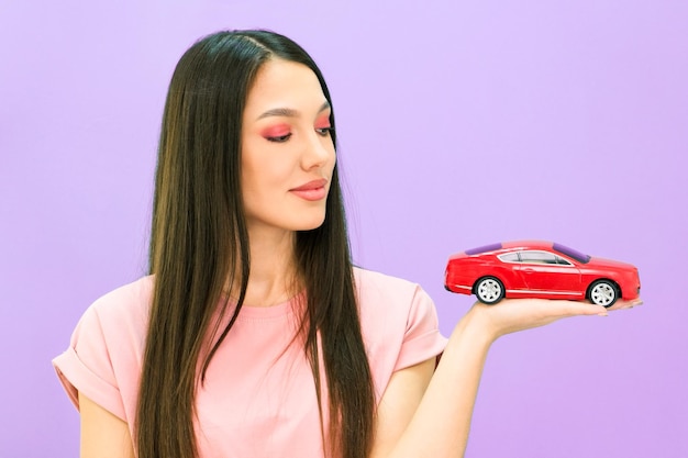 Driving school idea and concept student driver passed the exam drivers license portrait of a beautiful happy young woman holding a car in her hand