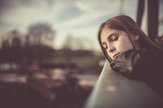 Droevig meisje dat zich op de brug bevindt