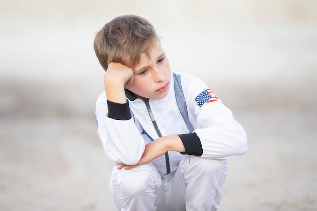 Droevige jongen verkleed als Amerikaanse astronaut