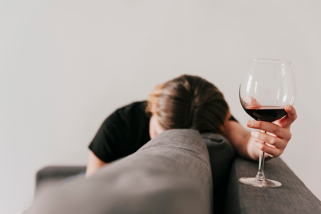 Foto droevige vrouw met wijn op laag