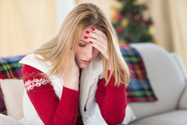 Droevige vrouwenzitting in de woonkamer op een laag