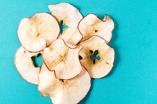 Droge appelspanen over aqua achtergrond met kopie ruimte.