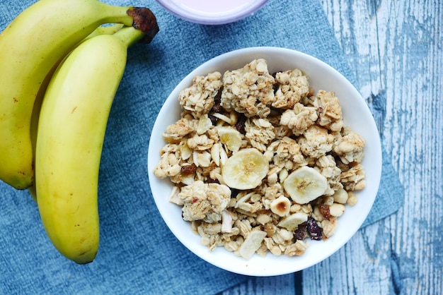 Droge bananenchips in een kom op zwarte tegels achtergrond