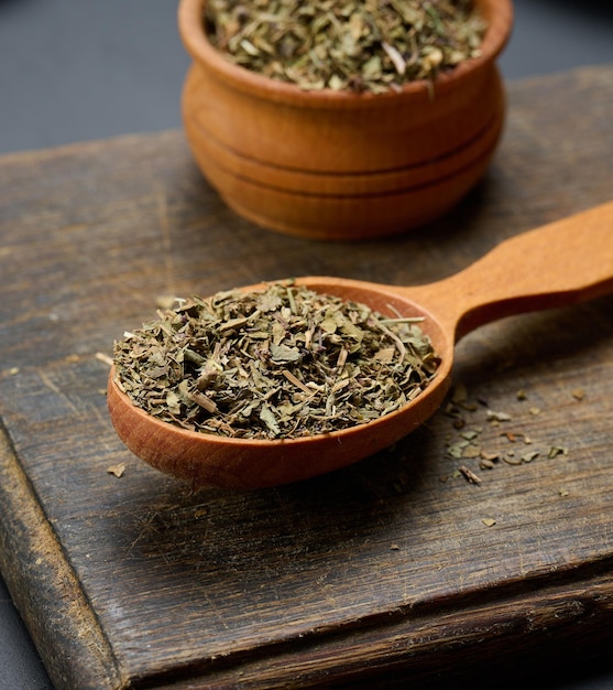 Droge basilicum in een houten lepel op tafel kruiden