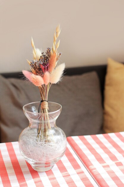 Foto droge bloemen in een vaas op tafel van café, italiaans tafelkleed op de tafel.