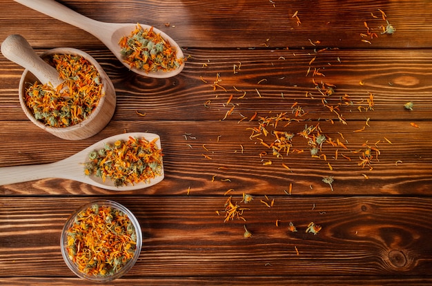 Droge calendula geneeskrachtige bloemen op een houten lijst.