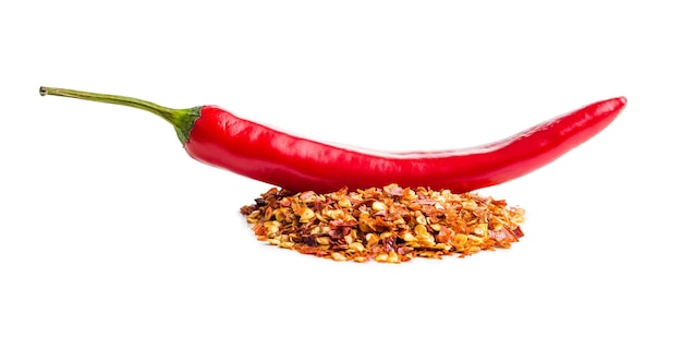 Droge chilipepervlokken en chilipepers Verpletterde rode pepers geïsoleerd op de witte achtergrond