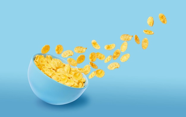 Foto droge cornflakes in een blauwe keramische plaat sommige cornflakes vliegen in de lucht traditioneel cornflakes ontbijtconcept