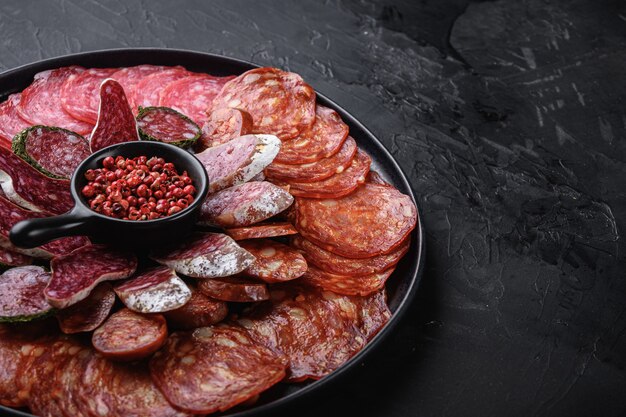 Droge gezouten worst gesneden chorizo, fuet, salami op achteroppervlak met kopie ruimte.