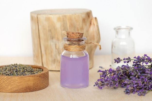 Droge lavendelbloemen houten kom fles met etherische lavendelolie doordrenkt water Natuurlijke cosmetische Spa