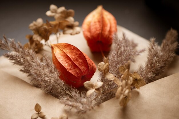 Droge physalis en hortensia bloemen versierd met pampagrasstelen gevouwen in ambachtelijke papieren envelop