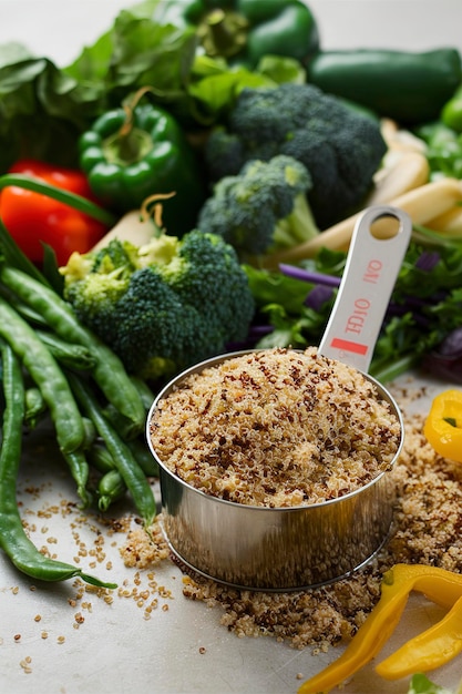 Droge quinoa in meetbeker en groene groenten glutenvrij en gezond kookconcept