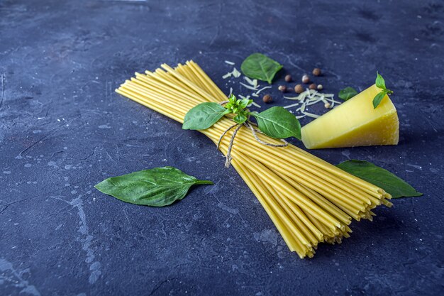 Droge spaghetti, basilicumblaadjes, parmezaan