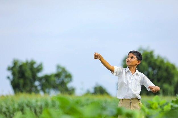 Dromen van vluchten! indiase kind spelen met speelgoed vliegtuig op groen veld