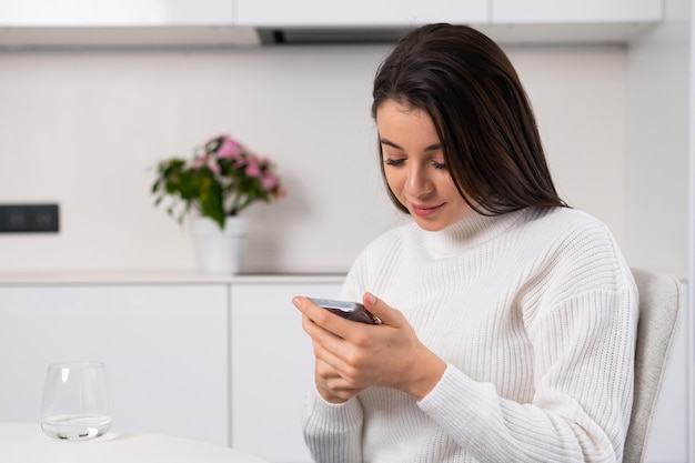 Dromerig duizendjarig meisje dat sociale media controleert met smartphone in haar handen