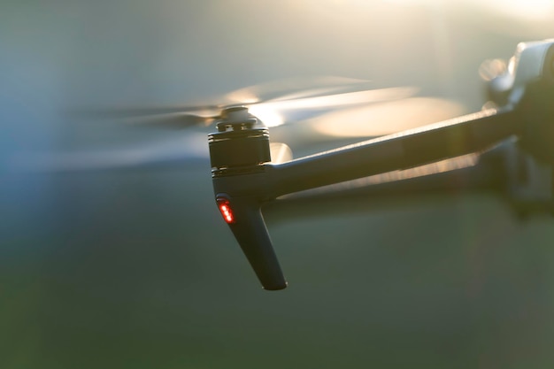 Drone aereo con eliche a rotazione rapida sfocate e videocamera che volano in aria