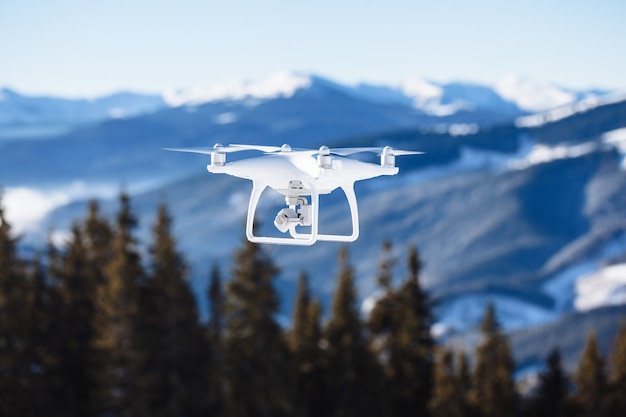 Drone copter flying with digital camera over the mountains