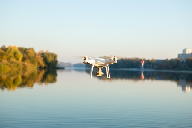 Drone copter with digital camera, blur river on background