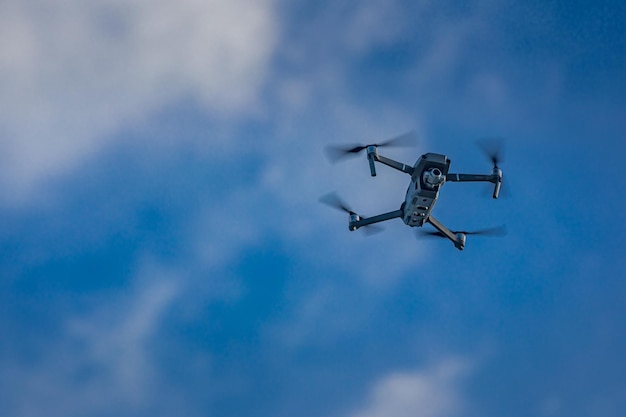 コピースペースで青い空を背景に飛行するドローンカメラを使用した最新のテクノロジーUAV写真ビデオ