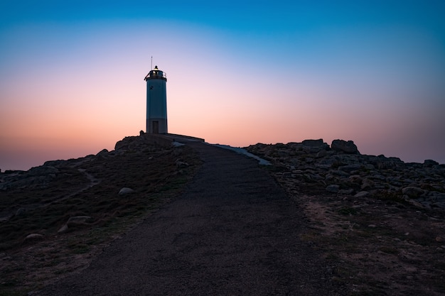 Drone flying over Lighthouse during sun rise.