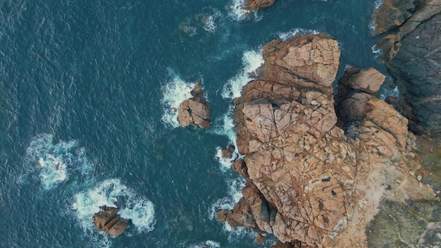 Drone oceaan wassen kliffen eiland top view golvende blauwe water schuimend op rotsen