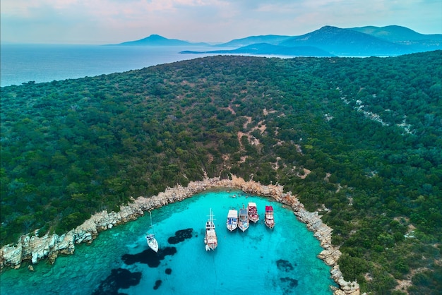 Drone photo aerial view of boats in sea bay among mountain