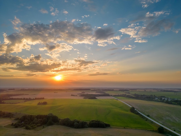 Фото с дроном молодого зеленого пшеничного поля во время захода солнца Аэроскоп фермерского поля Абстрактные узоры и прямые линии на сельскохозяйственных угодьях