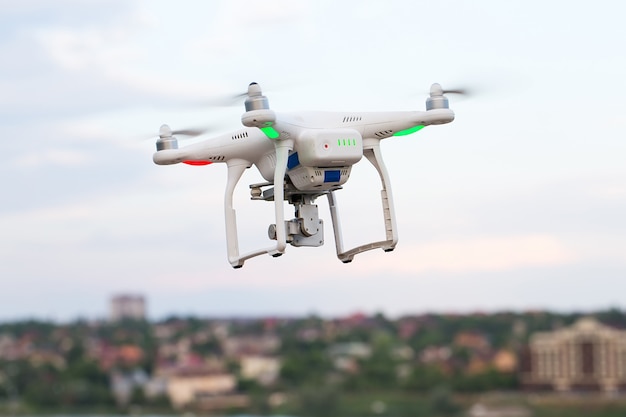 Drone quad copter with high resolution digital camera flying hovering over the city