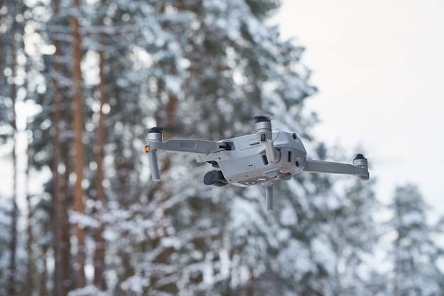 Drone quadcopter met camera vliegen in het woud van de winter