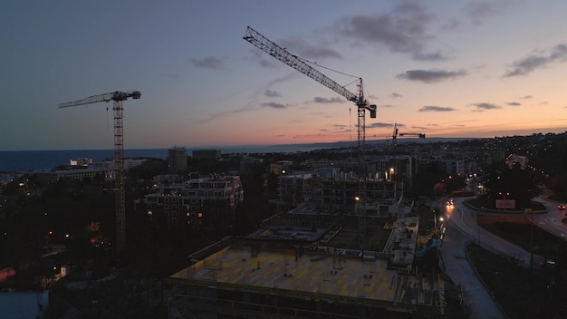 Drone video of a breathtaking flight around a hotel construction site on the seashore at evening