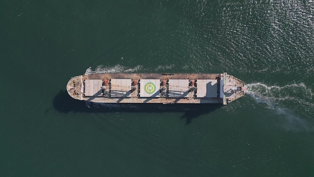 Drone video captures a topdown view of a bulk carrier ship floating in the sea