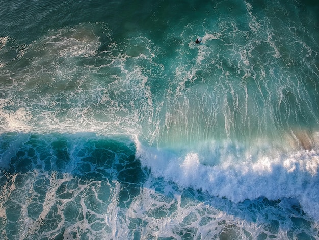 Drone view of beautiful turquiose sea waves breaking on sandy coastline aerial shot