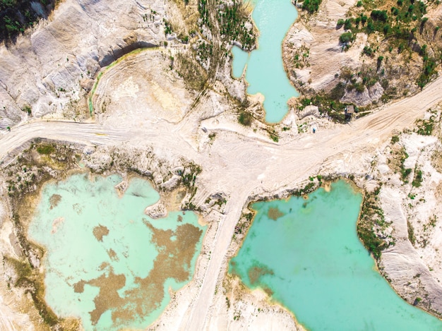 Drone view on a flooded kaolin quarry with turquoise water and white shore