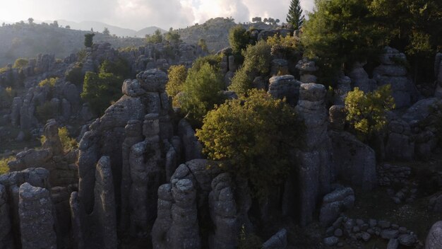 Drone view of majestic rock formations with green plants and coniferous trees beautiful nature lands