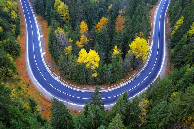 Drone view of a mountain road in an autumn forest