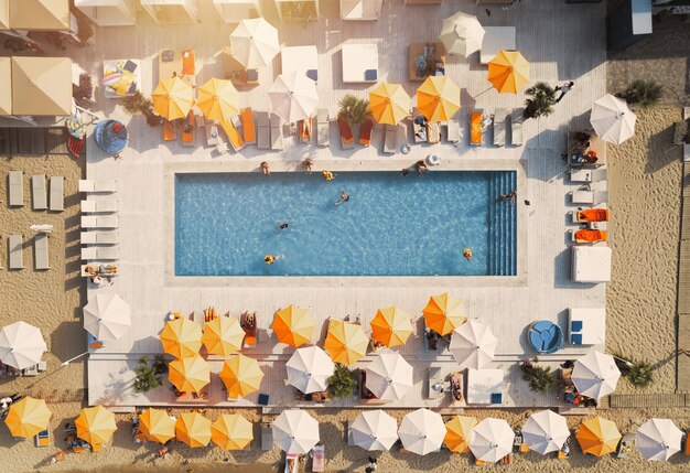 Drone view of people who relaxing in a swimming pool from