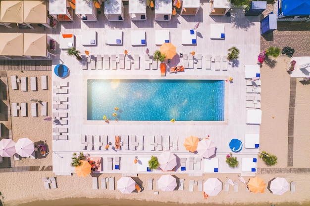 Drone view of people who relaxing in a swimming pool from