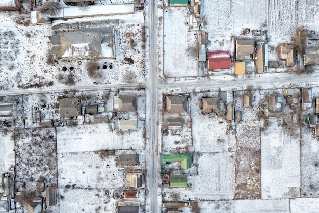 冬の小さな村のドローンビュー雪の空中写真の小さな家