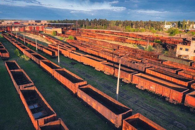 Drone-weergave van goederentreinen bij zonsondergang Oude spoorvrachtwagons met op spoorweg Luchtfoto van kleurrijke wagons Depot van goederentreinen Treinstation Zware industrie Industrieel vervoer