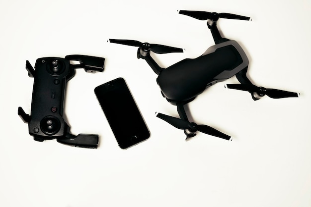 Drone with controller and smartphone on white background