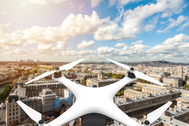 Photo drone with digital camera flying over a city with blue sky