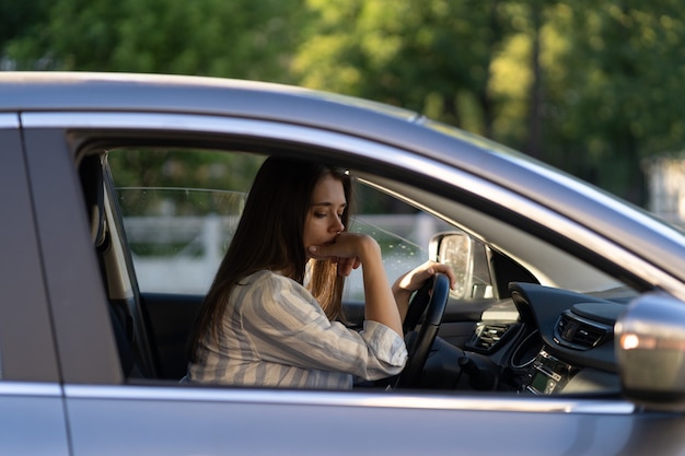 Dronken meisje rijdende auto ongelukkig vermoeide jonge vrouw in voertuig lijdend aan hoofdpijn of overdracht