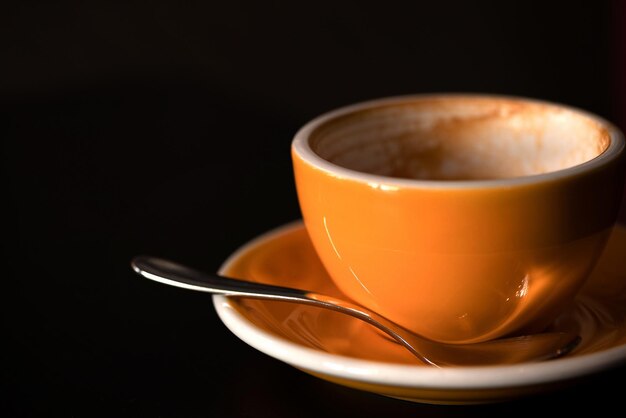 Dronken ochtendkoffie in lege gele kop Schuim van koffie aan de randen van een lege kop