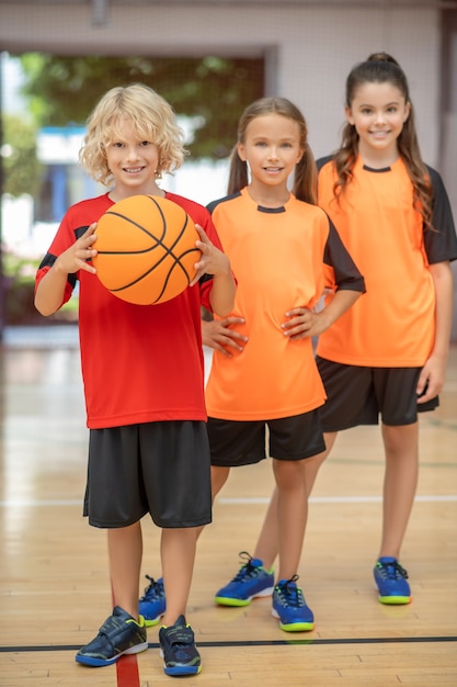 Droom team. Kinderen in sportkleding staan met een bal en kijken gelukkig